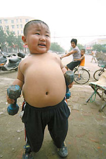 An overweight 4-year-old boy surnamed Wu in Xuchang, Central China's Henan Province, shows his prowess by lifting 5-kilogram dumbbells without difficulty. Wu, who tips the scales at 39.5 kilograms, is roughly twice the normal weight of a child his age.