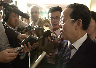 Chinese Ambassador to the UN Wang Guangya (R) speaks at the United Nations in New York July 13, 2006. The UN Security Council is discussing problems in Iran, North Korea and Lebanon.