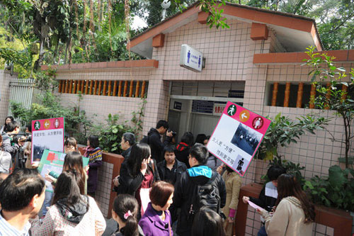 Female students hold banners and protest in front of a public toilet calling for more cubicles for women during an 'Occupy Men's Toilet' movement in Guangzhou city, South China's Guangdong province on Feb 19, 2012. S China city to add more toilets for women