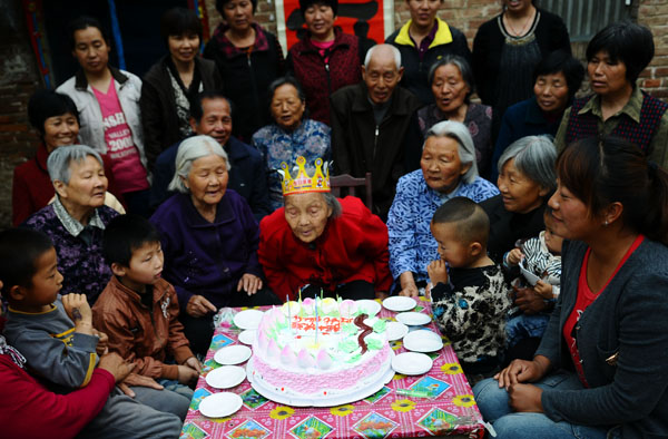 Wang Jingzhi celebrates her 113th birthday with family and neighbors in Yanggu county, Liaocheng city, East China's Shandong province May 27, 2013. Oldest centenarian in town celebrates 113th