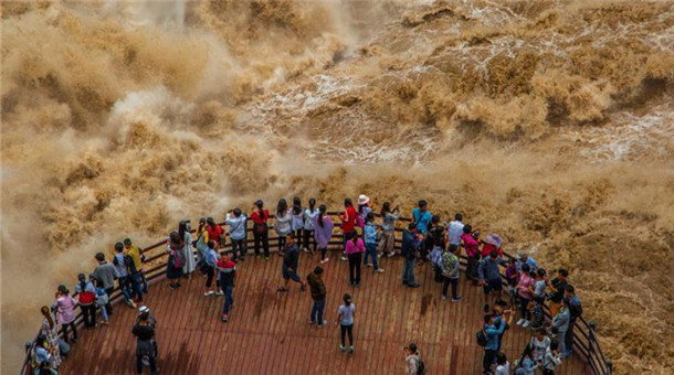 游客近距離觀賞虎跳峽“超級(jí)山洪” 近在咫尺大呼過(guò)癮