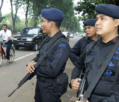 Indonesian police from the mobile brigade guard a Jakarta street January 5, 2005 near the Convention Centre where the international tsunami summit will be held on Thursday. Global leaders gathering in Jakarta to discuss the tsunami that devastated countries around the Indian Ocean will try to draw lessons from the disaster, including looking at a future warning system. [Reuters]