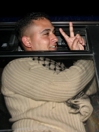 A Palestinian prisoner seen in a bus on the way out from Keziot jail in Israel February 21, 2005. Buses carried handcuffed Palestinians from an Israeli jail on Monday to be freed among 500 prisoners in the largest release for nearly a decade, meant to bolster peace efforts by Palestinian President Mahmoud Abbas. [Reuters]