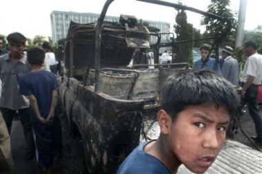 Local residents 
 stand at a burned car at the square outside the administration building in downtown Andijan, Uzbekistan, Friday, May 13, 2005. [AP]