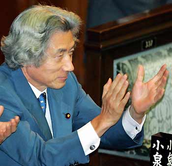 Japanese Prime Minister Junichiro Koizumi claps his hands at parliament's lower house as bills to privatise Japan's postal system, including the world's largest savings bank, were passed in the chamber in Tokyo October 11, 2005. Rejection of the bills in August by the upper house prompted Koizumi to call a September election which he cast as a referendum on privatisation, his long-held goal.