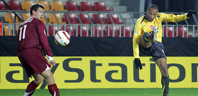 rsenal's Thierry Henry (R) chips the ball to score as Sparta Prague's Adam Petrous (L) looks on during their UEFA Champions League Group B soccer match at Sparta Stadium in Prague October 18, 2005.
