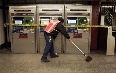 Milton Woodward, one of the first transit workers back on the job, sweeps up trash near subway ticket machines and turnstiles at the 34th Street subway station, Thursday, Dec. 22, 2005, in New York.