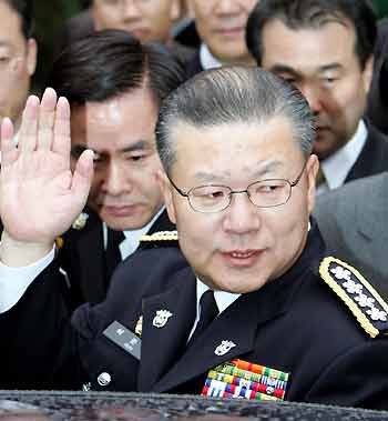 South Korean National Police Commissioner Huh Joon-young waves as he leaves the headquarters of the national police agency in Seoul December 30, 2005, after his retirement ceremony. Huh offered to resign on Thursday in order to take responsibility for the deaths of two farmers who clashed with police during a violent protest, a police spokesman said.