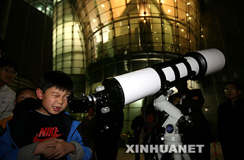 10月24日，一名兒童在北京天文館用天文望遠鏡觀賞月亮。 當日，搭載著我國首顆探月衛星嫦娥一號的長征三號甲運載火箭在西昌衛星發射中心三號塔架點火發射。連日來，北京天文館免費開放天文館和觀測儀器，吸引眾多市民前來觀月。 新華社記者李明放攝 