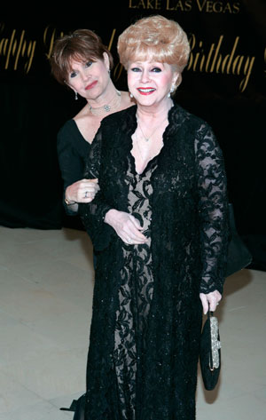 Actress Carrie Fisher (L) and her mother, actress Debbie Reynolds, pose as they arrive for Elizabeth Taylor's 75th birthday party at the Ritz-Carlton in Lake Las Vegas, in Henderson, Nevada February 27, 2007.