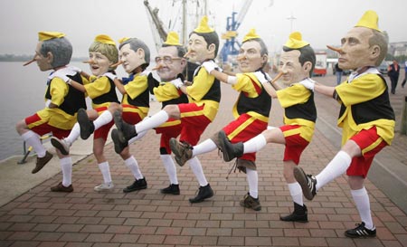 Activists from anti globalisation organisation Oxfam dressed as U.S. President George W. Bush, German Chancellor Angela Merkel, Canadian Prime Minister Stephen Harper, Italian Prime Minister Romano Prodi, Japanese Prime Minister Shinzo Abe, British Prime Minister Tony Blair, French President Nicolas Sarkozy and Russian President Vladimir Putin (L-R) in Pinocchio costumes pose for the media at Rostock's harbour June 5, 2007.