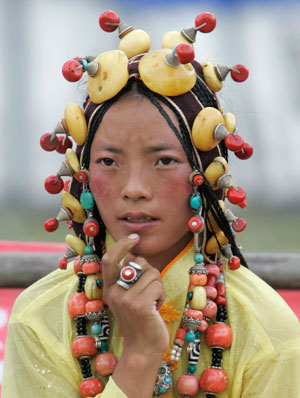A Tibetan woman in traditional costume rests on a street in Yushu, west China's Qinghai province, July 26, 2007.