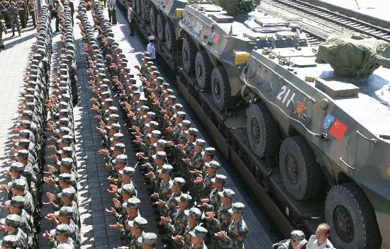 Chinese soldiers applaud during a ceremony that marks the transportation of first group of solider by railway for the exercise of 