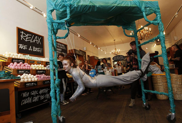 British performance artist Alice Newstead suspends from shark hooks pierced through her back at a cosmetic shop in San Francisco, California August 24, 2011 Hooked artist calls for shark protection