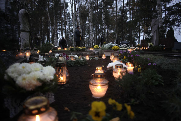 People gather near the graves of their relatives during All Saints Day in Panevezis Nov 1, 2011. Catholics mark All Saints Day on Tuesday by visiting cemeteries and graves of deceased relatives and friends. People memorize deceased on All Saints Day