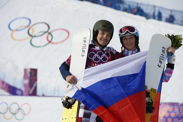 Russia's Vic Wild (L) and wife Alena Zavarzina pose with the Russian flag after the snowboard parallel giant slalom competition at the Sochi 2014 Winter Olympics in Rosa Khutor, Feb 19, 2014. Russia's snowboard couple medals together in Sochi