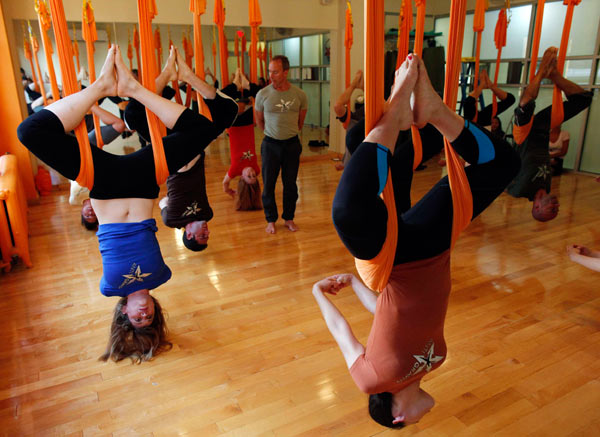 Yoga students hang like bats from the ceiling of a loft space in the heart of Manhattan's fashion district. In the Om Factory yoga studio, situated in a former garment factory, practitioners call it 'antigravity' yoga. Just hanging out