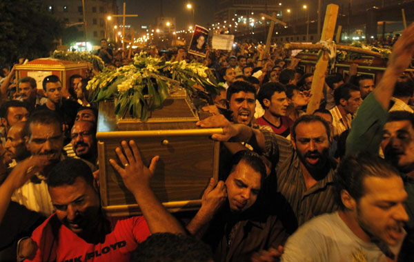 Egyptian Coptic Christians carry coffins as they make their way to Abassaiya Cathedral during a mass funeral for victims of sectarian clashes with soldiers and riot police, after a protest about an attack on a church in southern Egypt, in Cairo October 10, 2011. Egypt's finance minister resigns after clash