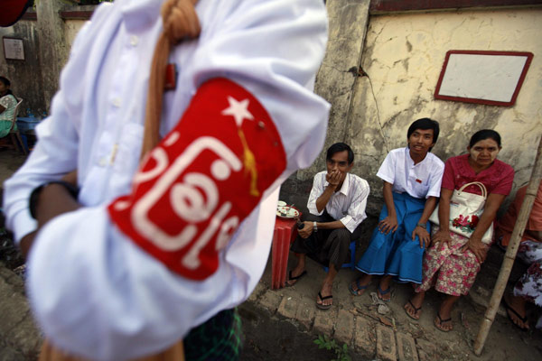 Members of the National League for Democracy (NLD) party sit at a tea shop on a street in front of the building where the NLD are holding their congress, in Yangon March 10, 2013. Aung San Suu Kyi re-elected opposition leader