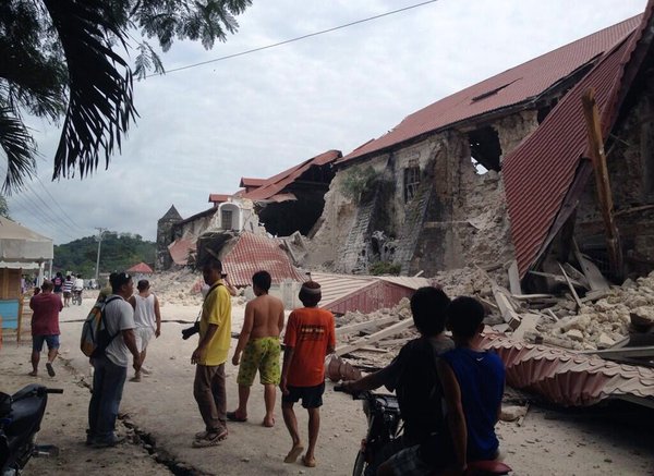 People walk past the damaged Church of San Pedro in the town Loboc, Bohol, after a major 7.2 magnitude earthquake struck the region, on Oct 15, 2013. 20 killed in strong Philippine quake